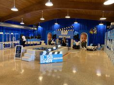 an indoor event with two baby dolls in the center and blue curtains on the walls