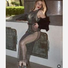 a woman posing for a photo in a silver dress