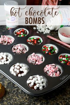 a muffin tin filled with cupcakes and marshmallows next to candy canes