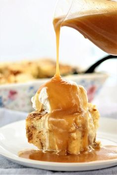 caramel sauce being drizzled over a piece of cake on a plate