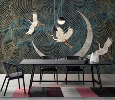 two birds flying over a table in front of a wall mural