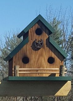 a wooden bird house with a clock on the top