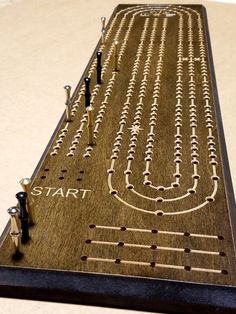 a wooden board game with people standing on it and lines drawn across the board to spell start