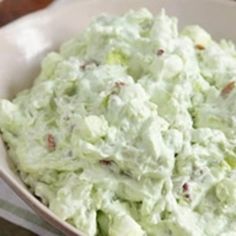 a white bowl filled with cucumber salad on top of a table