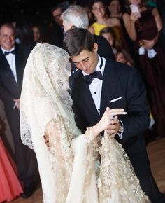 a man in a tuxedo and woman in a wedding dress on the dance floor