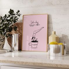 a pink poster on a shelf next to a potted plant