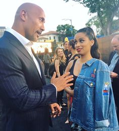 a man in a suit standing next to a woman