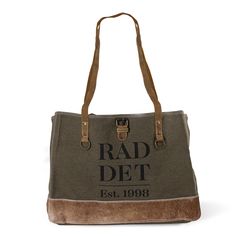 Introducing the RAD Canvas Bag – a versatile companion that seamlessly blends modern style with rustic charm. Featuring green canvas, brown leather handles, and natural brass hardware, this bag exudes a timeless yet contemporary appeal. The sturdy bottom, made of neutral hair-on-hide, adds durability and an earthy texture. With a spacious interior and outer pockets for convenience, the RAD Canvas Bag is the perfect fusion of modern functionality and rustic allure. Brown Duck Canvas Tote Bag, Shopping Satchel Tote With Brass Hardware, Tote Satchel With Brass Hardware For Shopping, Duck Canvas Bags With Leather Double Handles, Duck Canvas Bags With Leather Handles, Brass Hardware Tote Satchel For Shopping, Duck Canvas Satchel Bag With Leather Handles, Duck Canvas Satchel With Leather Handles, Khaki Canvas Bag With Handles