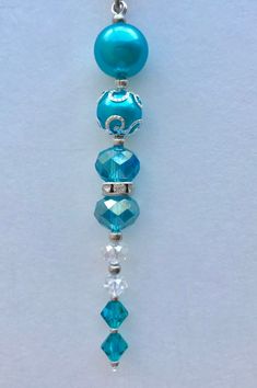 a blue beaded necklace hanging from a chain