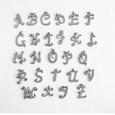 the letters and numbers are made up of silver colored metal beads with swarong crystals