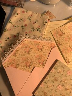 there are many papers on the table with flowers and doily around them, including one that has been folded