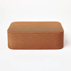 a brown leather box sitting on top of a white surface