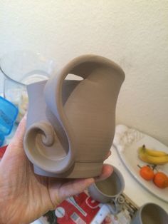 a person is holding a clay sculpture in their hand and it looks like an elephant's tail