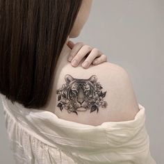 a woman with a tiger tattoo on her shoulder