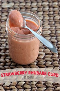 strawberry rhubarb curd in a glass jar with a spoon on top