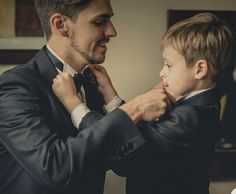 a man helping a young boy put on his tie