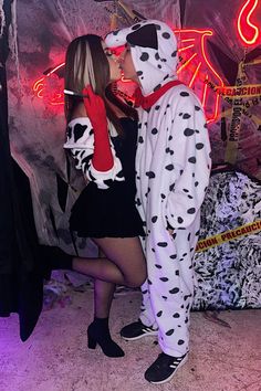 a man and woman dressed up in dalmatian costumes standing next to each other