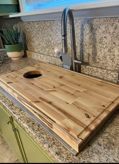 a wooden cutting board sitting on top of a kitchen counter