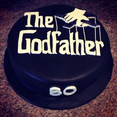 a black cake with white lettering on it that says, the godfather 80