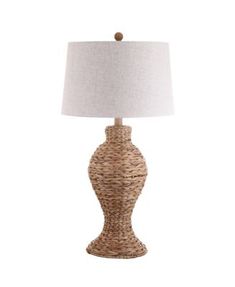 a table lamp with a white shade on the base and a brown wicker design