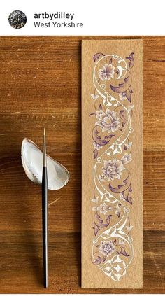 an image of a wooden bookmark with flowers on it and a spoon next to it