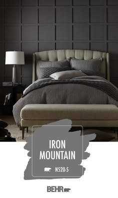 the iron mountain bed frame is upholstered with grey linens and has a large headboard