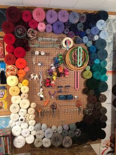 a peg board with lots of different colored yarns on it and various items hanging from the pegboard