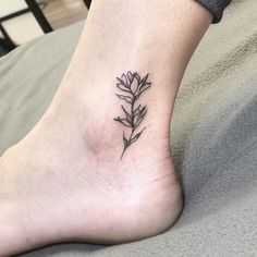 a small flower tattoo on the ankle