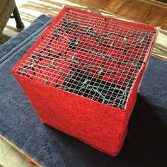 a red box sitting on top of a blue rug