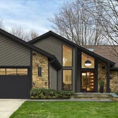 a house that is in the middle of some grass and has two garages on each side