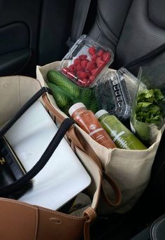 a bag filled with fruits and vegetables in the back seat of a car