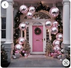 a pink door surrounded by christmas decorations