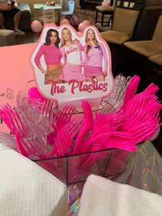 pink plastic utensils in a basket with the logo of the plastics on it