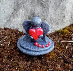 an elephant figurine with a heart on it's back sitting in the dirt