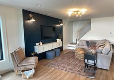 a living room filled with furniture and a flat screen tv on top of a wooden floor