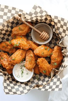 a basket filled with chicken wings and dipping sauce