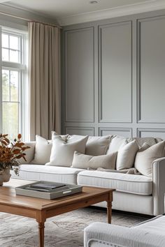 a living room filled with white furniture and lots of window sill space next to a coffee table