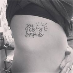 a woman's stomach with the words you are my sunshine tattoo on her side