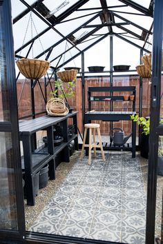 the inside of a greenhouse with potted plants and other things on it's shelves