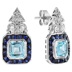 A pair of vintage aquamarine drop earrings, each earring consisted of an emerald cut aquamarine surround by a row of French cut sapphires, suspended from a round diamond-set top. These eye-catching earrings would pair perfectly with a sleek cocktail dress or evening gown. Information Metal: 18K White Gold Width: 11 mm. Length: 20 mm. Weight: 5.10 g. (approx. in total) Backing: Push Back Center Gemstones Type: Aquamarine Shape: Emerald Cut Size: 5 x 5 mm. Number: 2 Weight: 1.40 Carat (approx. in Luxury Diamond Earrings With Gemstone Accents, Luxury Multi-stone Diamond Earrings For Formal Occasions, Luxury Multi-stone Earrings For Formal Occasions, Luxury Multi-stone Diamond Earrings For Anniversary, Elegant Multi-stone Diamond Earrings, Elegant Multi-stone Diamond Earrings For Formal Occasions, Multi-stone White Gold Earrings For Formal Occasions, Formal Multi-stone Fine Jewelry Earrings, Formal Multi-stone Diamond Earrings