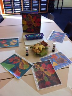 the table is covered with cards and other art supplies, including an arrangement of flowers