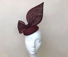 A classic and sophisticated burgundy oversized bow headpiece.  Perfect for any wedding or Royal Ascot (meets Royal Enclosure size regulations) or that finishing touch for your special occasion.  The disc is approx 16 cm in diameter and stands about 25cm high Secured with elastic or a satin covered hairband in a choice of colours to blend your hair colour. I recommend elastic with this shape.   Each piece is handmade by me for you, using the highest quality materials which takes about 5 days, if you have a specific date you need the headpiece please get in touch and I will ensure you receive in good time. If you would like the piece to be made to match your outfit, or adapted please contact me (a swatch can be sent or matched to your required colour) Presented in a branded hat box.  Please Elegant Adjustable Burgundy Hats, Adjustable Elegant Burgundy Hat, Fitted Mini Hat With Bow For Wedding, Formal Burgundy Fitted Hat, Elegant Burgundy Hat For Kentucky Derby, Elegant Fitted Brown Headpiece, Elegant Brown Mini Hats For Formal Occasions, Elegant Fitted Brown Fascinator, Hat Wedding Guest