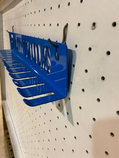 a blue sign hanging on the side of a white wall next to holes in it