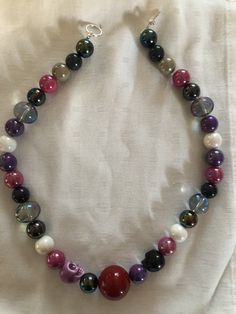 Handmade beaded choker with white skull bead, purple, pink , grey and clear iridescent beads. Purple Beaded Choker With Round Beads, Purple Colorful Beads Choker Jewelry, Purple Colorful Beaded Choker Jewelry, Iridescent Adjustable Necklace With Round Beads, Iridescent Adjustable Round Bead Necklaces, Adjustable Purple Choker With Round Beads, Beaded Skull, Choker Necklaces, Beaded Choker