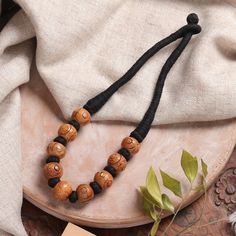 Elevate your fashion game with this captivating necklace that catches the eye. Presented by India's Rahul Jain, the striking haldu wood beads, meticulously carved and arranged on a sleek black cotton cord, add a bold and sophisticated touch to any ensemble, ensuring you stand out with chic bohemian flair. Bone Bead Necklace, Brown Jewelry, Wood Bead Necklace, Chic Bohemian, Jewelry Clasps, Bone Beads, Bohemian Necklace, Black Jewelry, Colourful Necklace