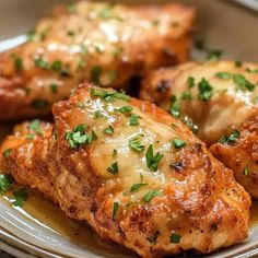 three pieces of chicken covered in cheese on a plate