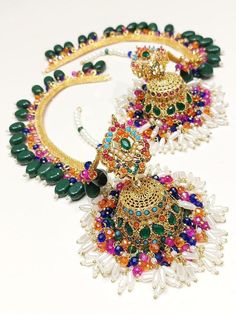 This exquisite piece of jewellery from My Jewel Box is perfect for any special occasion. The Indian/Pakistani Bridalwear Partywear Jewellery set includes a stunning Manat Jhumka and a Bahubali Style Long Sahara Chain, both adorned with multiple natural gemstones. The excellent cut grade of the stones and the intricate craftsmanship make this piece a true work of art. Celebrate love, family, and beauty with this Ethnic & Regional Style Asian jewellery set that is perfect for engagements, weddings Asian Jewelry, Love Family, Wedding Jewelry Earrings, Jewel Box, Jewellery Set, Wedding Earrings, Bridal Wear, Jewelry Set, Party Wear