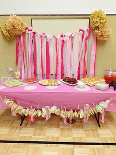 a pink table topped with lots of desserts