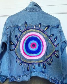 a denim jacket with an eye painted on it