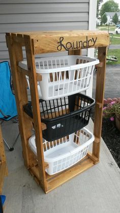 three baskets are stacked on top of each other in front of a wooden stand with the word laundry written on it